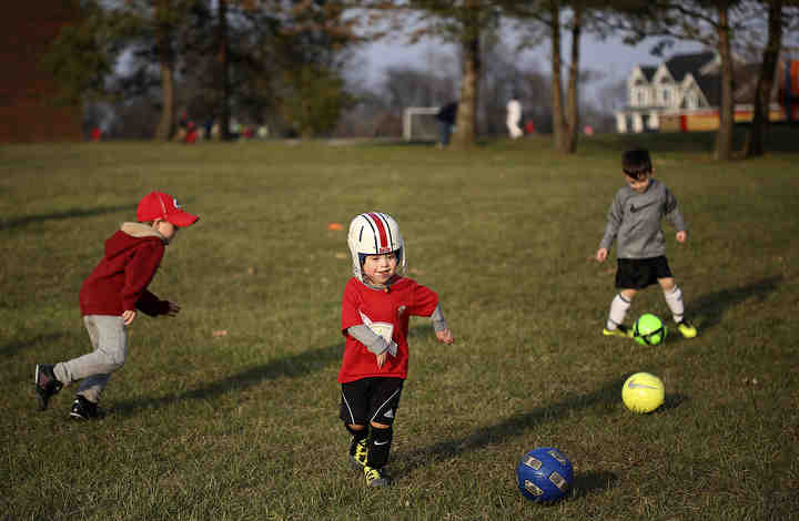 Marco Ranalli, 4, was born without muscles in his arms due to an unexplained event that happened in utero. With help of his parents, two older brothers, teachers and therapists, Marco overcomes many obstacles with creativity, persistence and patience. Here, he kicks the ball at his first soccer practice on April 11, 2018. He wears a helmet when he his outside of his home to protect his face and mouth since he cannot break his fall.  (Jonathan Quilter / The Columbus Dispatch)